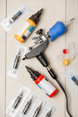 Dövme sanatçılarının aletleri ve malzemeleri ahşap masada.