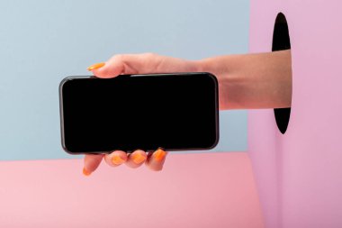 Mavi ve pembe arka planda bir telefon tutan kadınların yakın plan fotoğrafları.