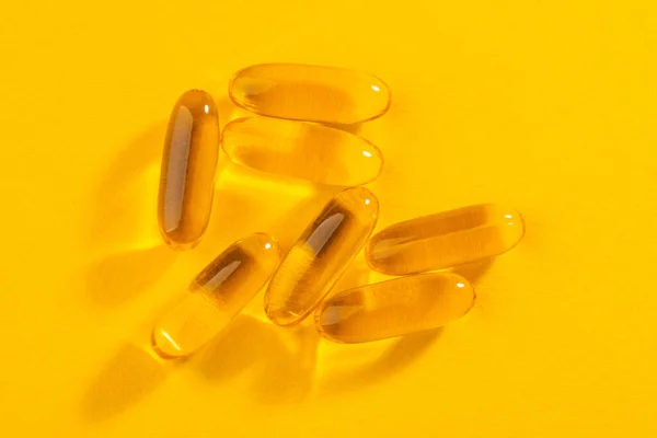 Close-up on cod liver oil capsules on orange background — Stock Photo, Image