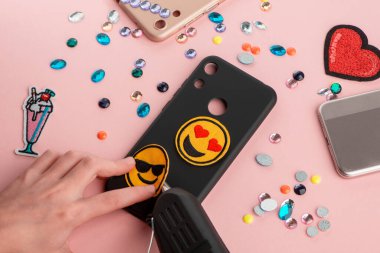 Siyah telefon kılıfına sarı gülücükler takan kız