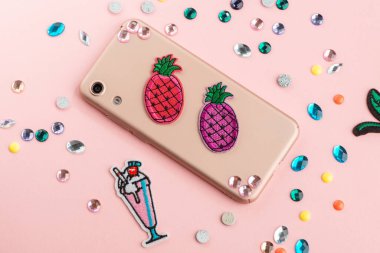 Renkli ananas parçaları ve bej telefon kılıfındaki yapay elmaslar.
