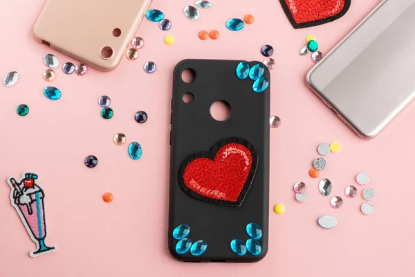 Blue rhinestones and red heart patch on black phone case — Stock Photo, Image