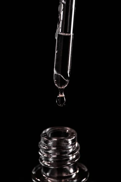 Close-up on a pipette with a drop of fluid falling into a vial — Stock Photo, Image