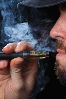 Siyah arka plan üzerine Elektronik Sigara İçilmeyen genç adam