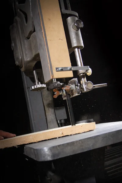 Um artesão cortando uma tábua de madeira com serra de fita — Fotografia de Stock