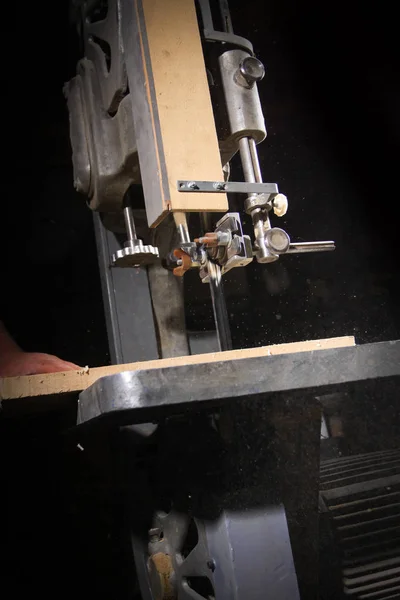 Un artigiano che taglia una tavola di legno con una sega a nastro — Foto Stock