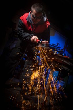 Plazma kesici ile çelik plaka üzerinde çalışan genç adam