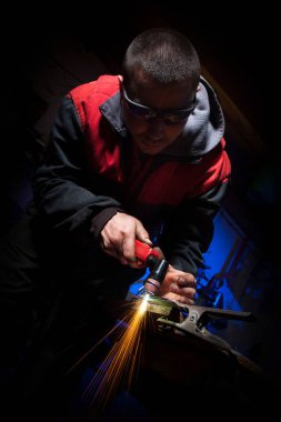 Plazma kesici ile çelik plaka üzerinde çalışan genç adam