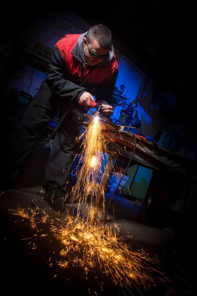 Junger Mann arbeitet mit Plasmaschneider auf Stahlplatte — Stockfoto