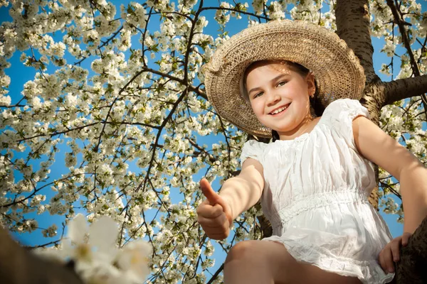 Cute little girl playing on tree in early spring — Stock Photo, Image