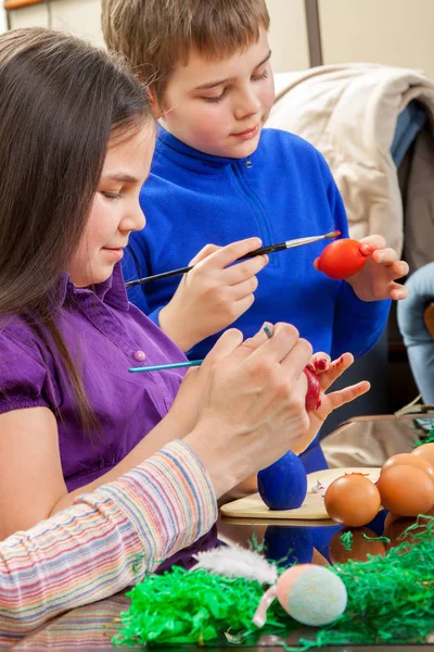 Moeder en haar kinderen verf paaseieren — Stockfoto