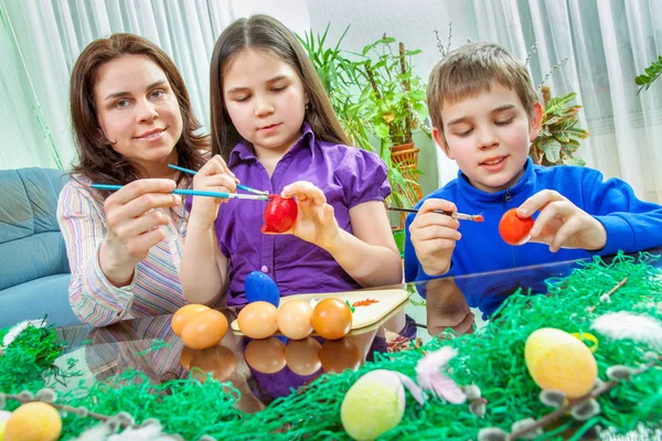 Mãe e seus filhos pintam ovos de Páscoa — Fotografia de Stock