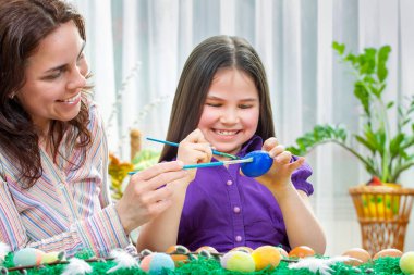 Anne ve çocukları Paskalya yumurtaları boya