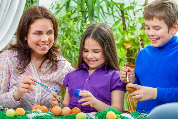 Mother and her children paint easter eggs — Stock Photo, Image