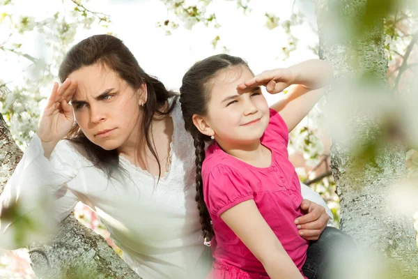 Linda niña jugando en el árbol a principios de primavera — Foto de Stock