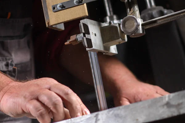 Un artigiano che taglia una tavola di legno con una sega a nastro — Foto Stock