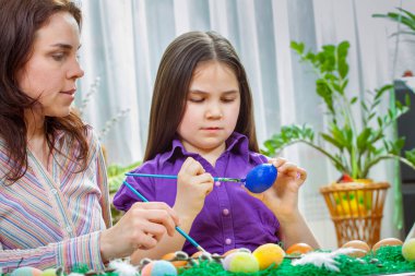 Anne ve çocukları Paskalya yumurtaları boya