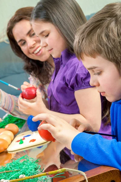 Moeder en haar kinderen verf paaseieren — Stockfoto