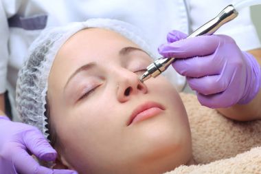 Diamond microdermabrasion, peeling cosmetic. woman during a micr clipart