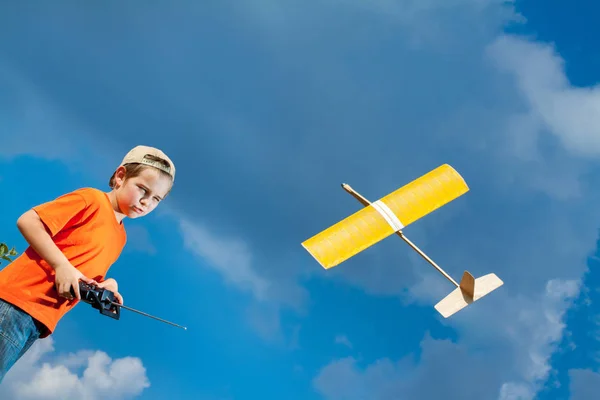 Ragazzino che gioca con il giocattolo fatto a mano RC aeroplano — Foto Stock