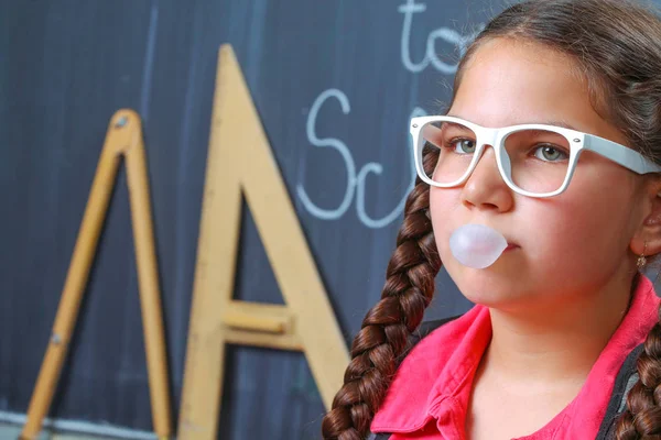 Happy school girl in front of the blackboard — Stock Photo, Image