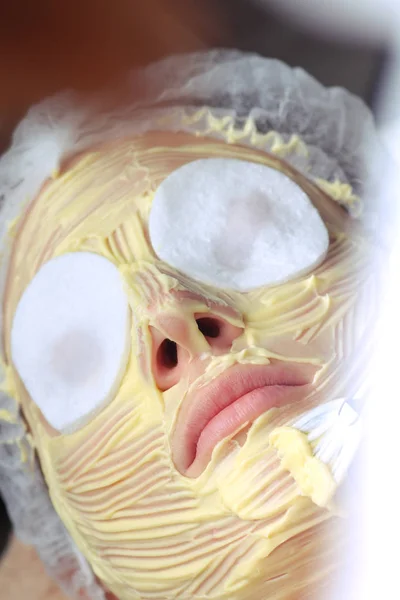 Wellness-Konzept. junge Frau mit nährstoffreicher Gesichtsmaske in Schönheitssalon — Stockfoto