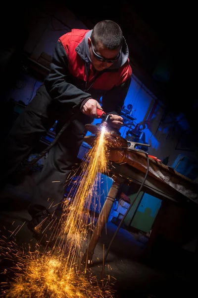 Plazma kesici ile çelik plaka üzerinde çalışan genç adam