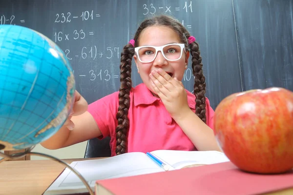 Lycklig skolflicka framför svarta tavlan — Stockfoto