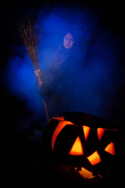 A bruxinha com abóbora de Halloween — Fotografia de Stock