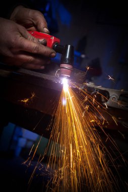 Plazma kesici ile çelik plaka üzerinde çalışan genç adam