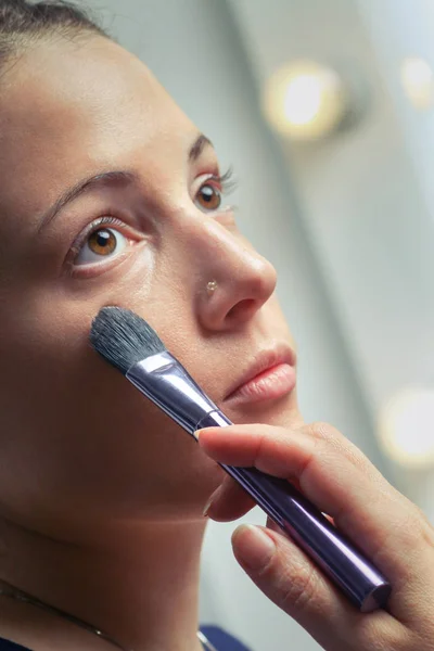 Mooie jonge volwassen vrouw toepassing cosmetische kwast — Stockfoto