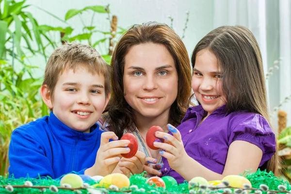 Mãe e seus filhos pintam ovos de Páscoa — Fotografia de Stock