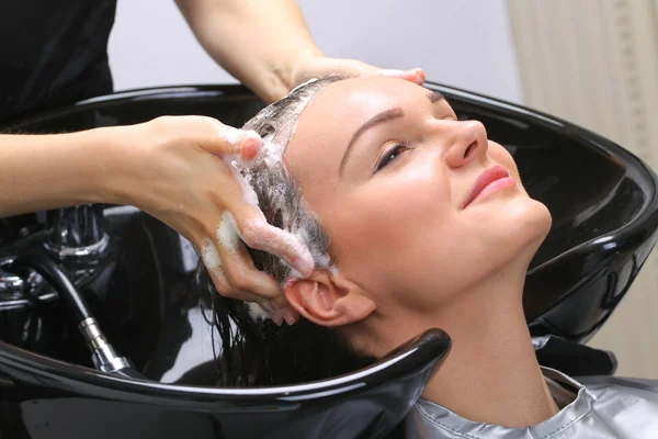 Hairdresser washing woman's hair in hairdresser salon