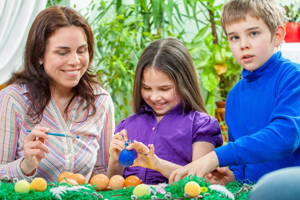 Mother and her children paint easter eggs — Stock Photo, Image