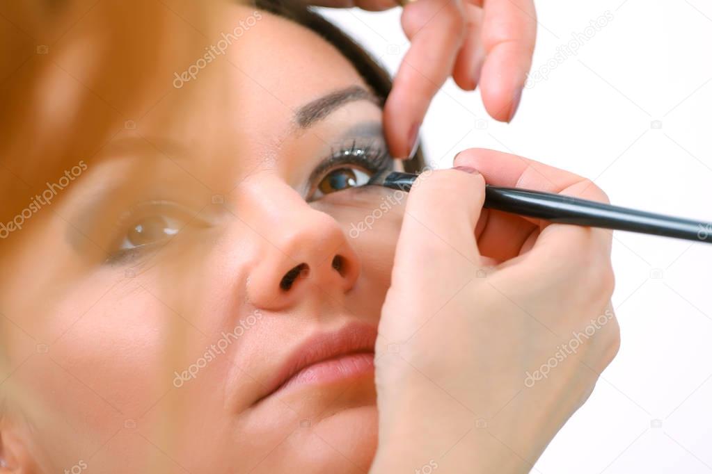 Professional Make-up artist doing glamour model makeup at work