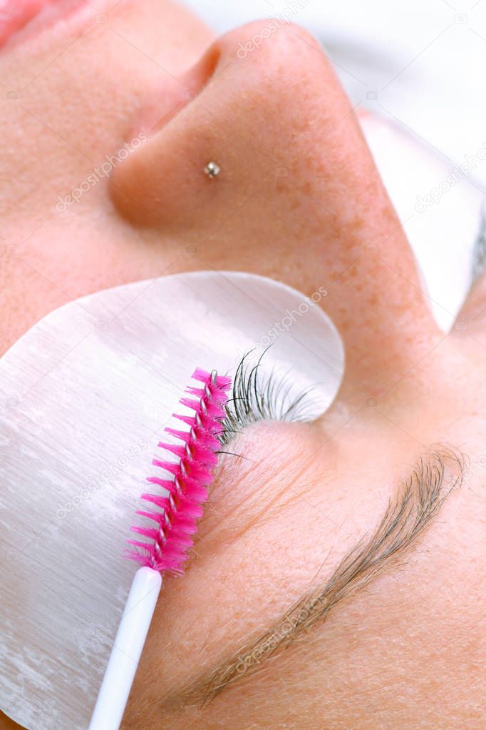 Eyelash extension procedure, woman eye with Long eyelashes