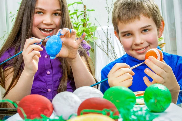 Mother and her children paint easter eggs — Stock Photo, Image