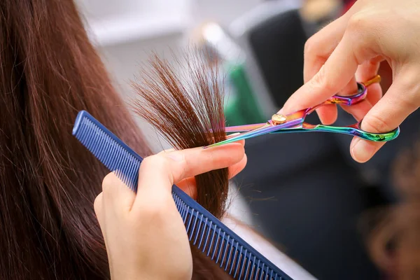 Крупный план парикмахера, стригущего волосы женщины в красоте — стоковое фото
