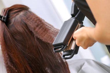 Stilist el styling demir düzleştirme kadınla yakın çekim 