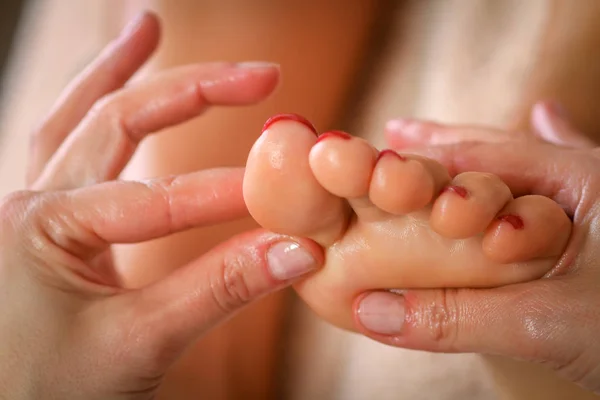 Massagetherapeutin massiert Beine einer Schwangeren — Stockfoto