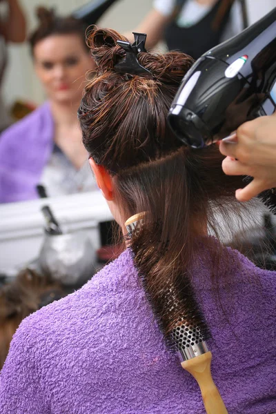 Girl in beauty salon while an hair stylist dry her hair — Stock Photo, Image