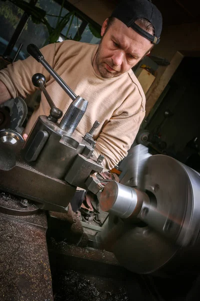 Metal worker working on lathe