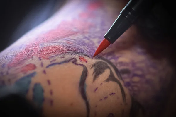 Kvinnliga tatuerare att göra tatuering på en mäns arm — Stockfoto