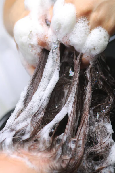 Kapper wassen van de haren van de vrouw in de kapsalon — Stockfoto