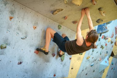 Genç çocuk üzerinde kapalı tırmanma duvarı tırmanma eğitimi