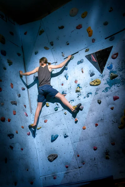 Teenage Boy Training Climbing On Indoor Climbing Wall