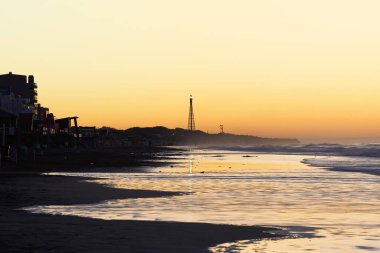 Güneş doğarken deniz fenerinin muhteşem manzarası ve boş kumsaldaki açık gökyüzü.