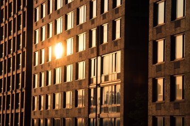 Günbatımında New York 'taki tuğla binanın camına yansıyan güneş ışığı.