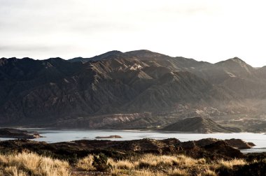 Tarladan göle güzel bir manzara And Dağları 'nın arkasında bir sonbahar günü şafağın yumuşak ışığıyla.