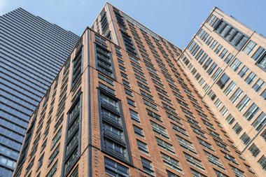 Mavi gökyüzü olan kırmızı ve mavi Manhattan binalarının alçak açılı görüntüsü